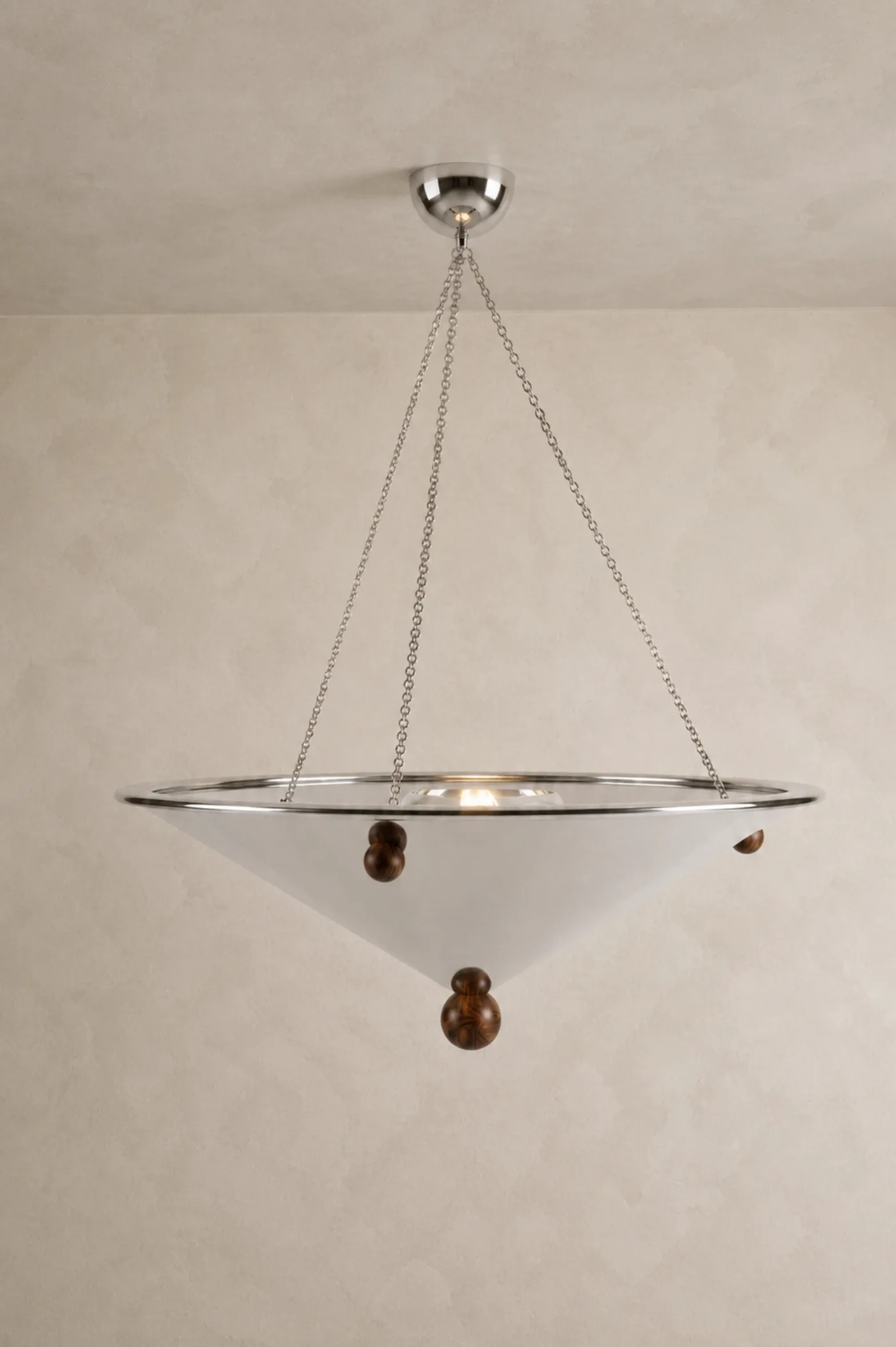 La suspension : vasque de verre opalin cerclée de chrome, suspendue à de fines chaînes